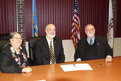 Redlands Community College Chief Academic Officer Rose Marie Moore (left), Cameron University President John McArthur (middle) and Redlands Community College President Jack Bryant sign an articulation agreement 