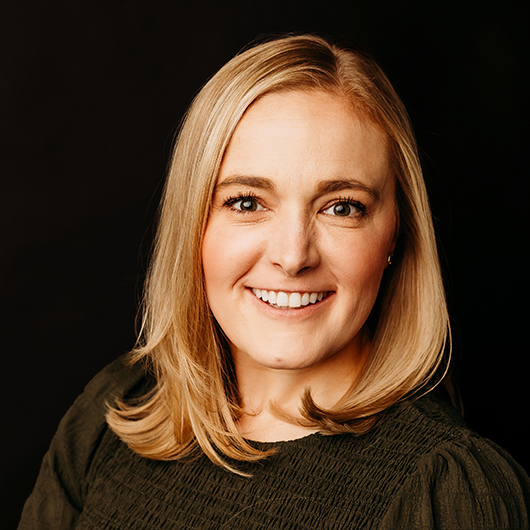 Woman with blonde hair and a textured brown blouse