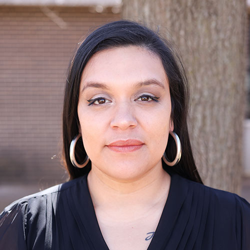 Woman with black straight hair and hoop earrings