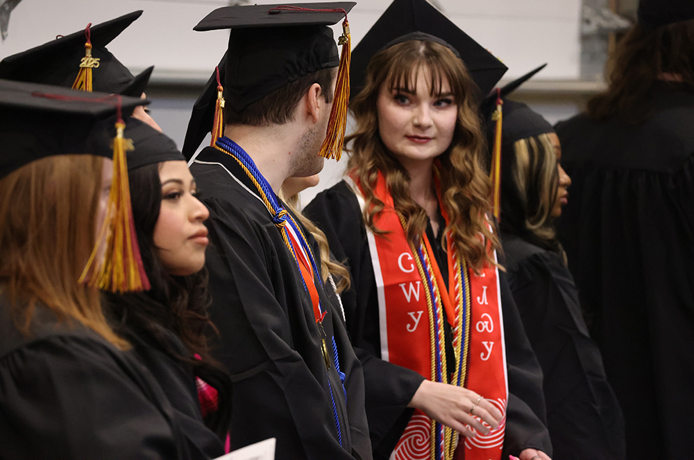 Graduates in black robes and red and tan tassles