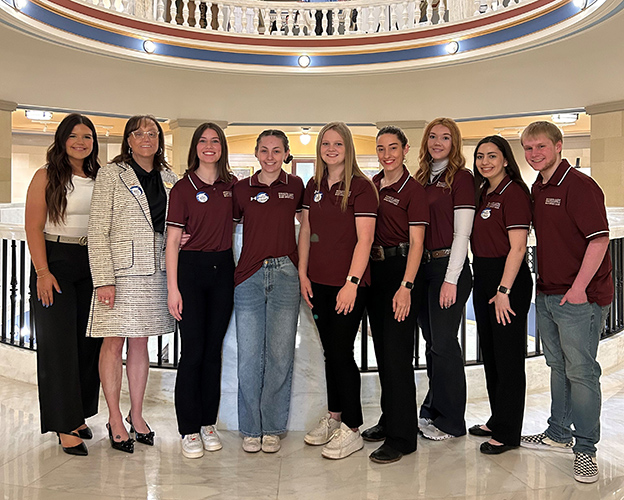 7 female students and 1 male students standing with Redlands President Jena Marr in the capitol rotunda