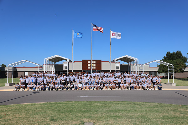 Redlands students are standing in front of the flagpoles on campus.