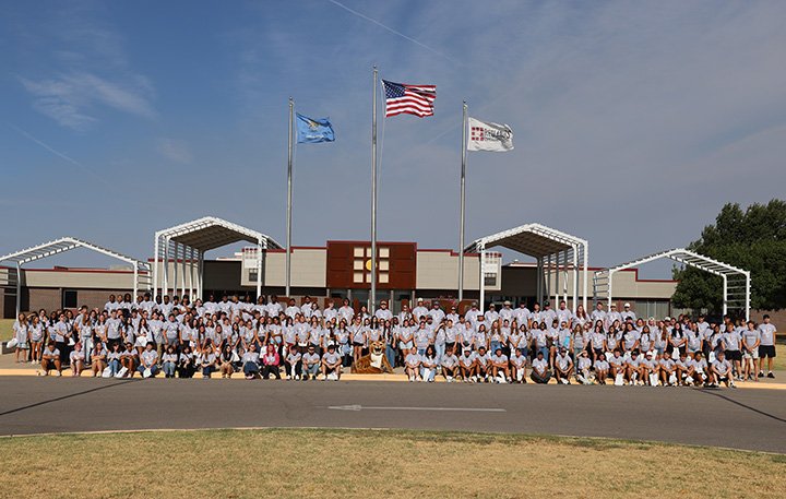 group of students standing in front of campus