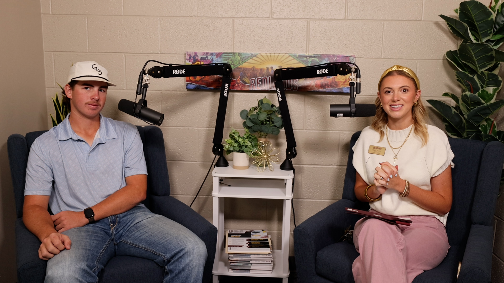 A college student, left, and podcast host, right, smile and sit next to microphones