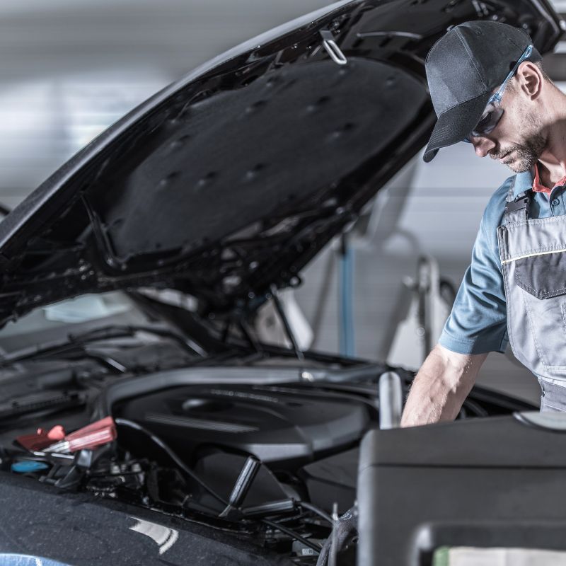 Auto technician works under the hood of a vehicle
