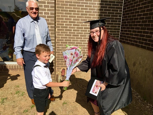 GOALS program graduate receives flowers from her son and father