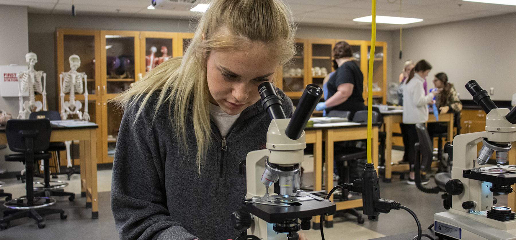 Science student using microscope