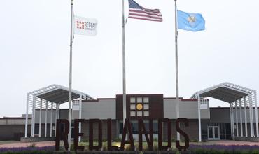 Campus entrance with flags and Redlands letters